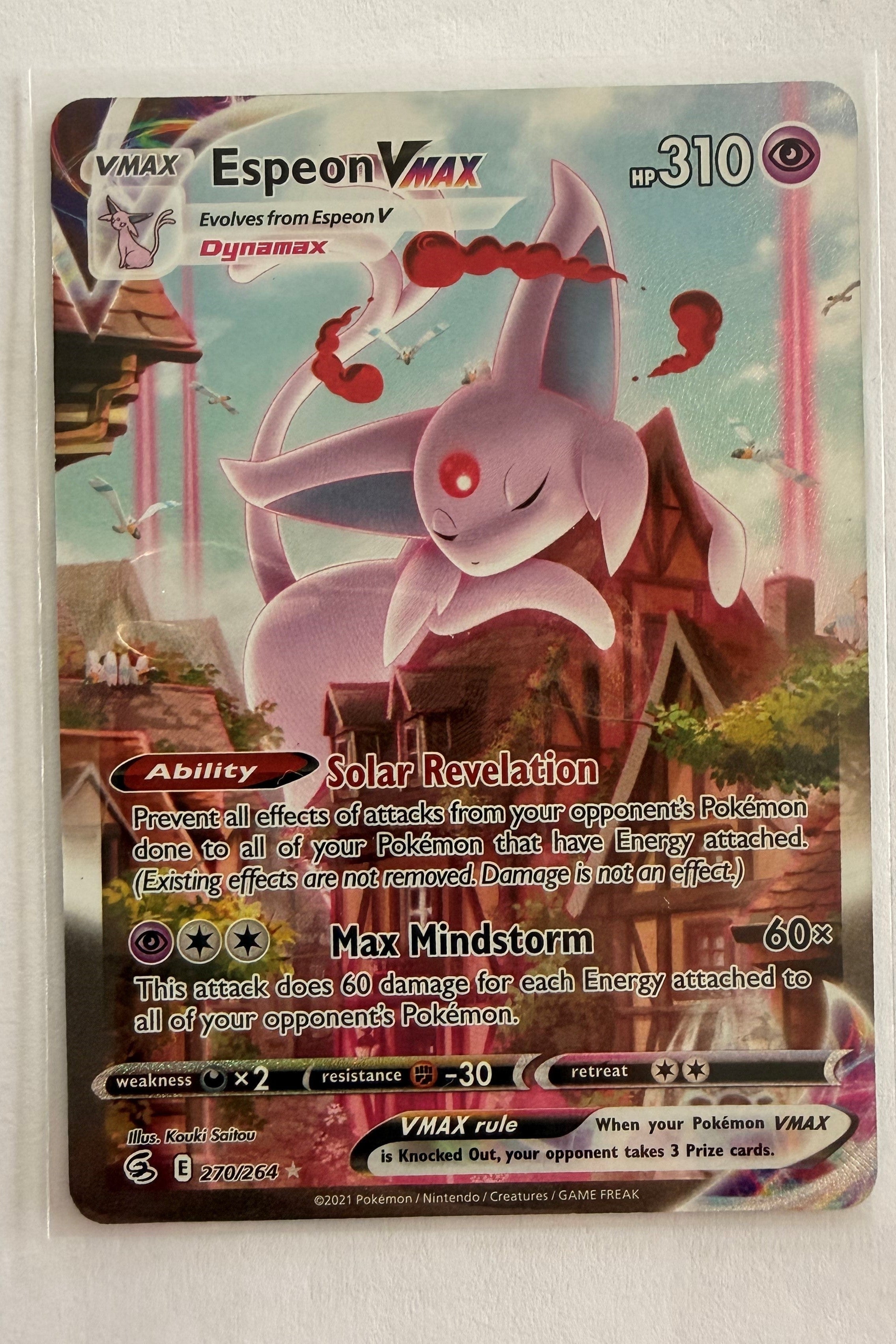 Espeon VMAX trading card with detailed artwork and text on a light gray background